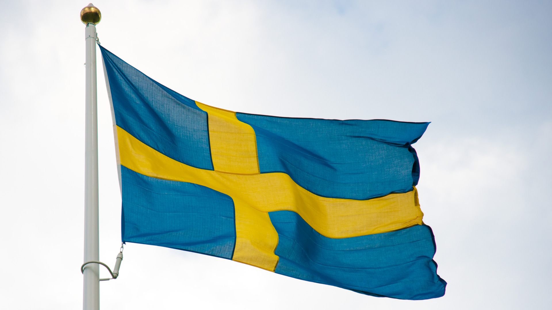 Svenska flaggan som är blå med ett gult kors 